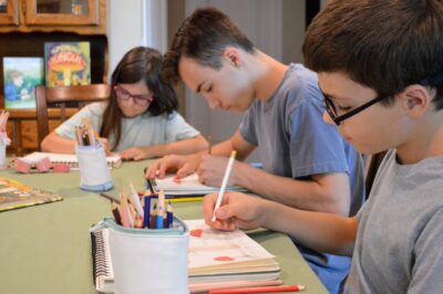 children learning about science and drawing in his nature journal
