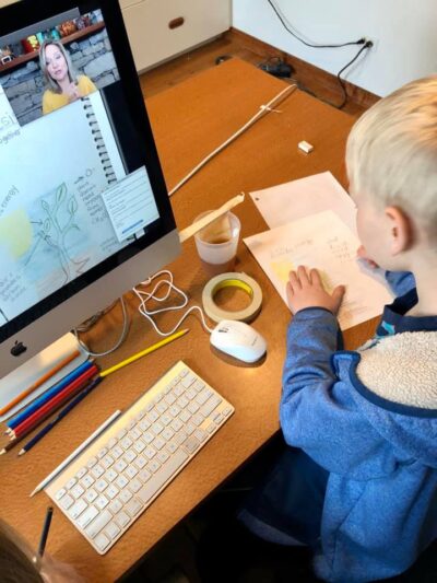 child learning about science and drawing in his nature journal