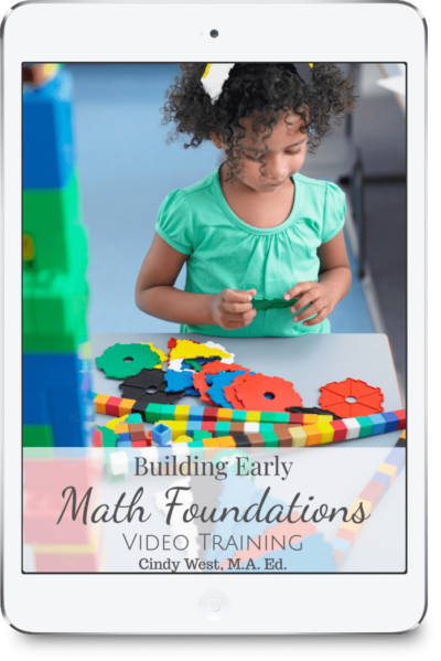 A child in a green shirt playing with colorful math manipulatives.